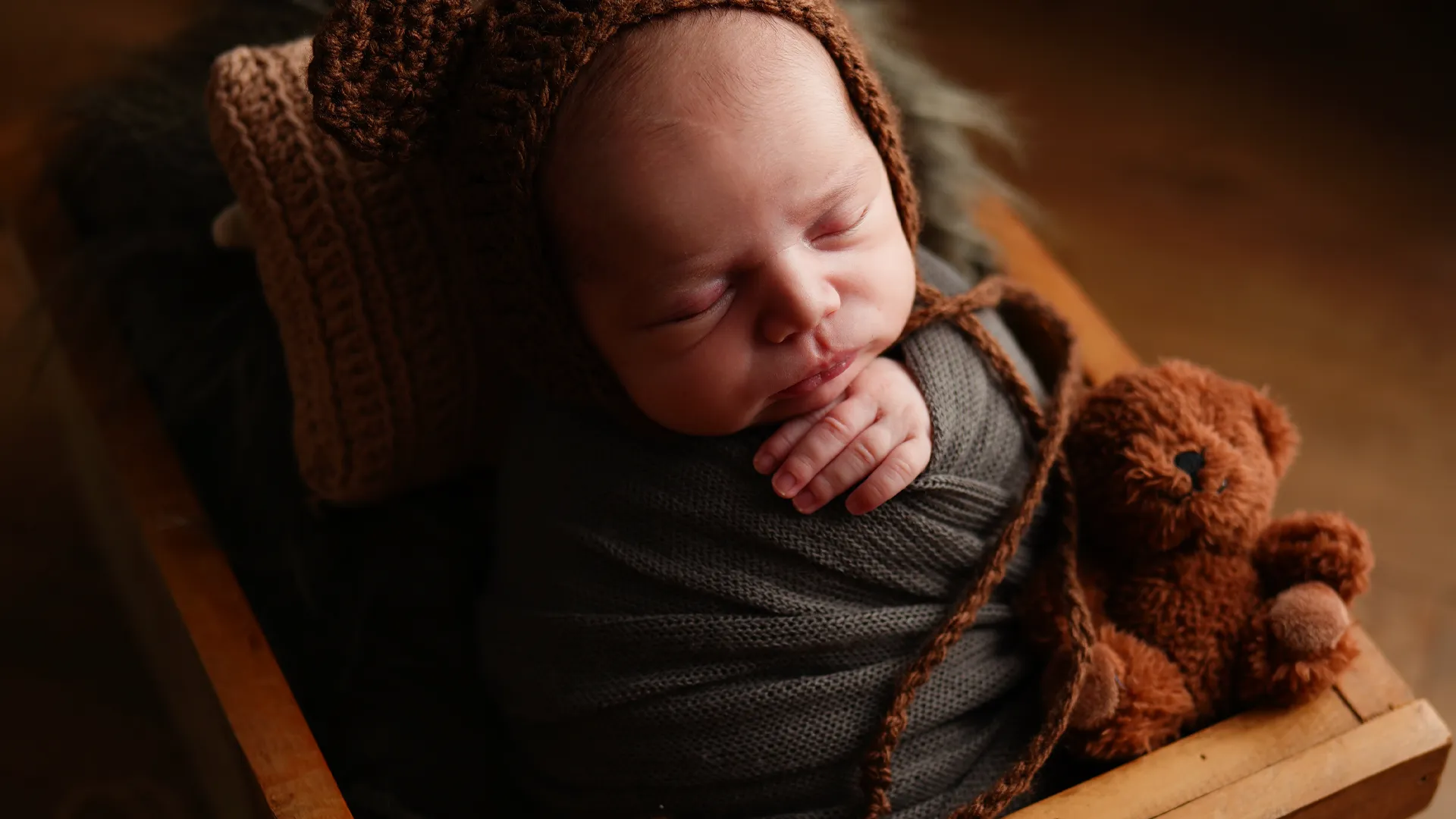 Recém-nascido dormindo com toca de ursinho e um teddy bear — ensaio newborn em Brasília